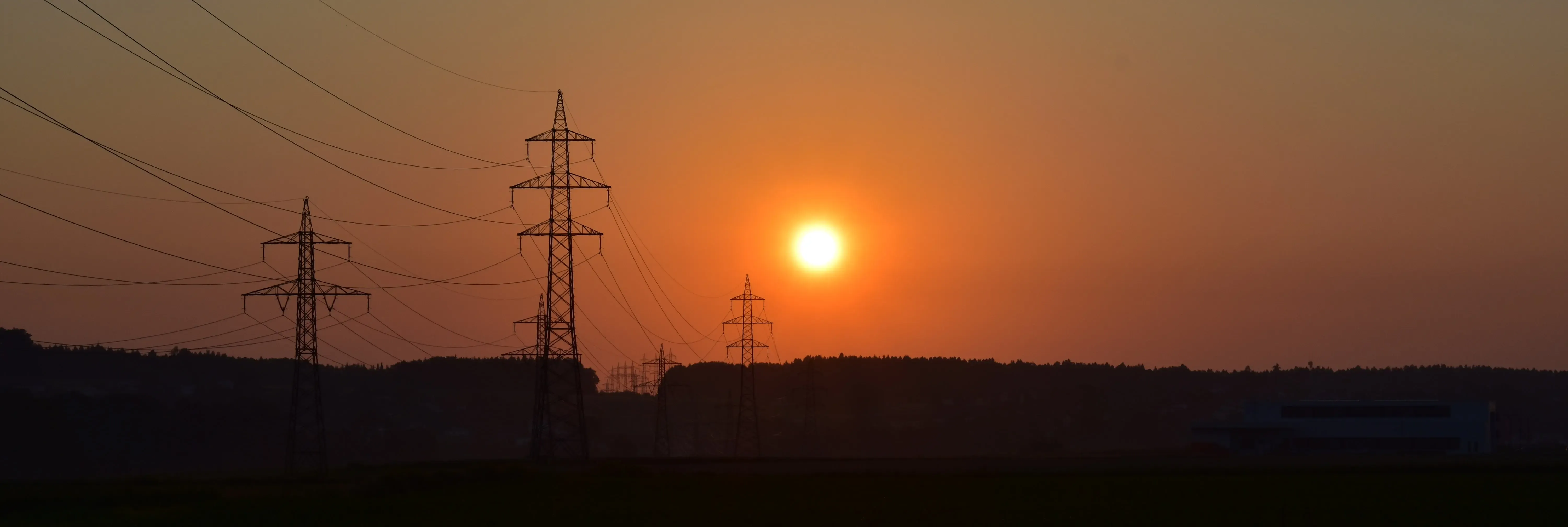 A sunset with electircal masts in the background